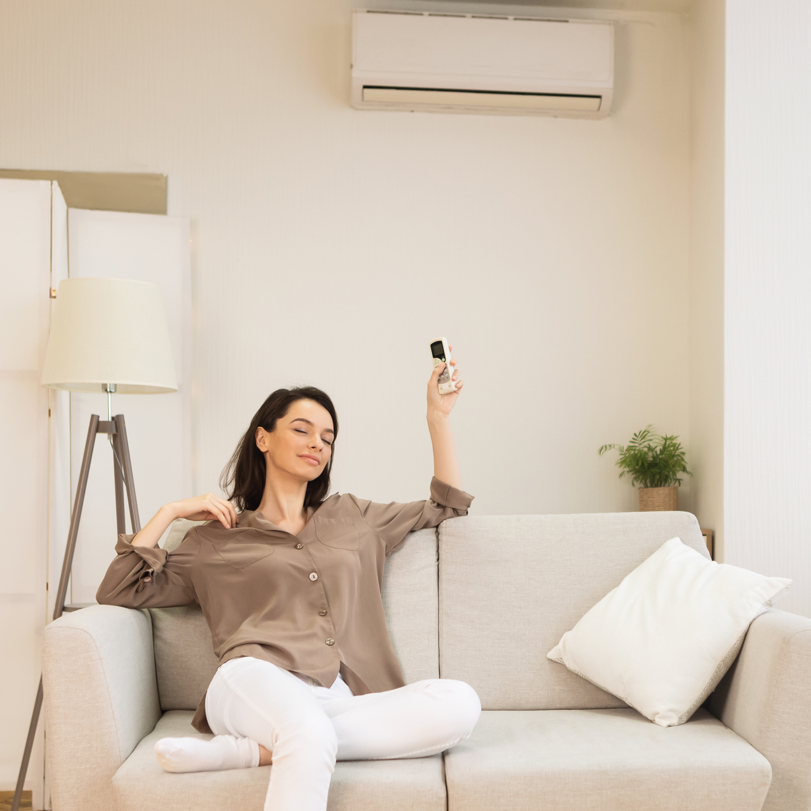 Home owner turning on her new air conditioning unit in her living room