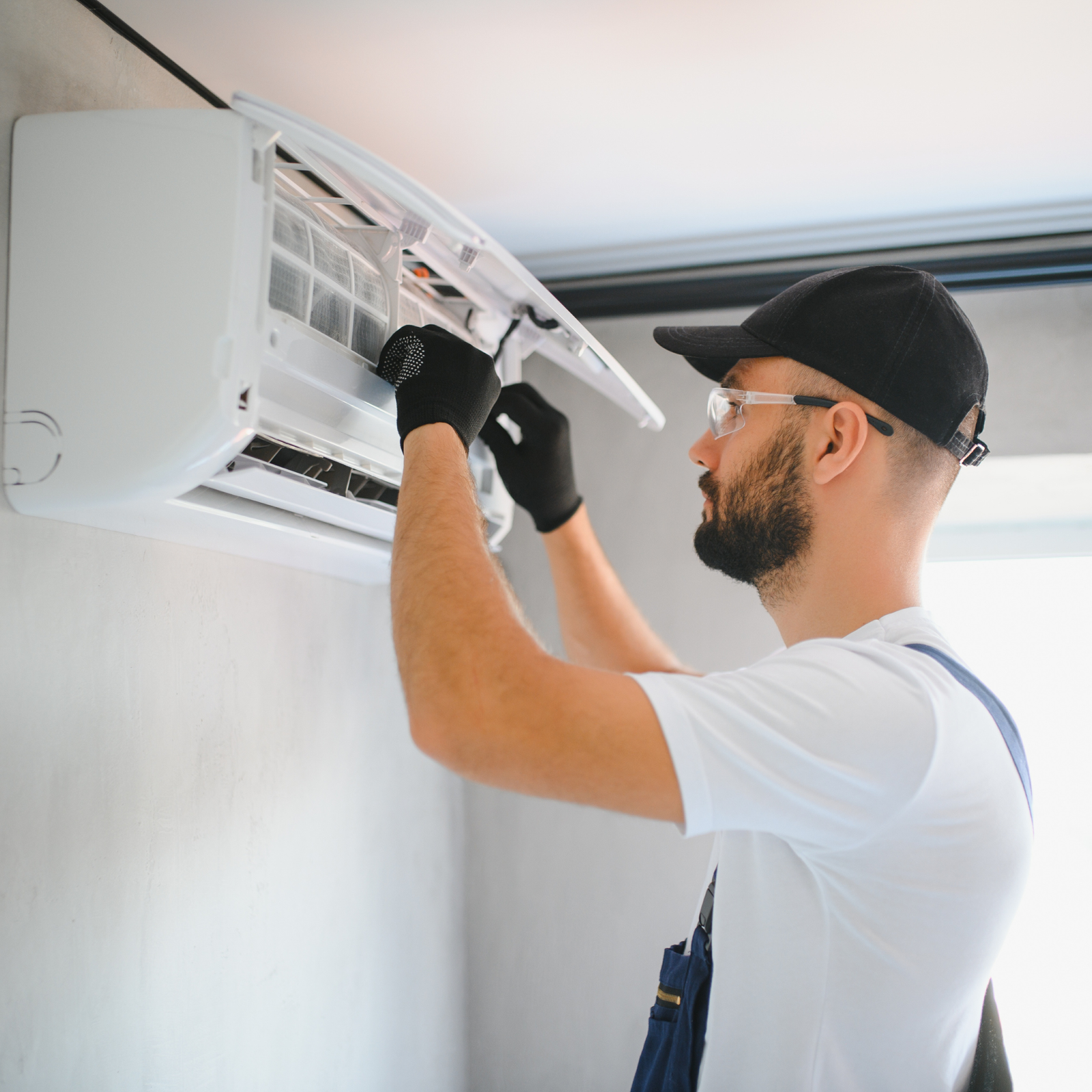 Air conditioning engineer maintaining a home air con unit