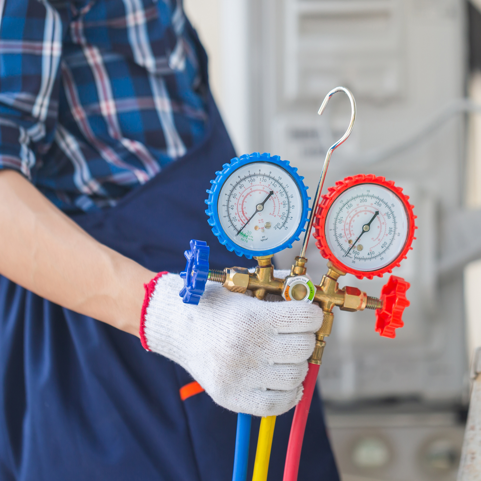 An Air conditioning engineer holding testing equipment to test the hoe owners air conditioning system