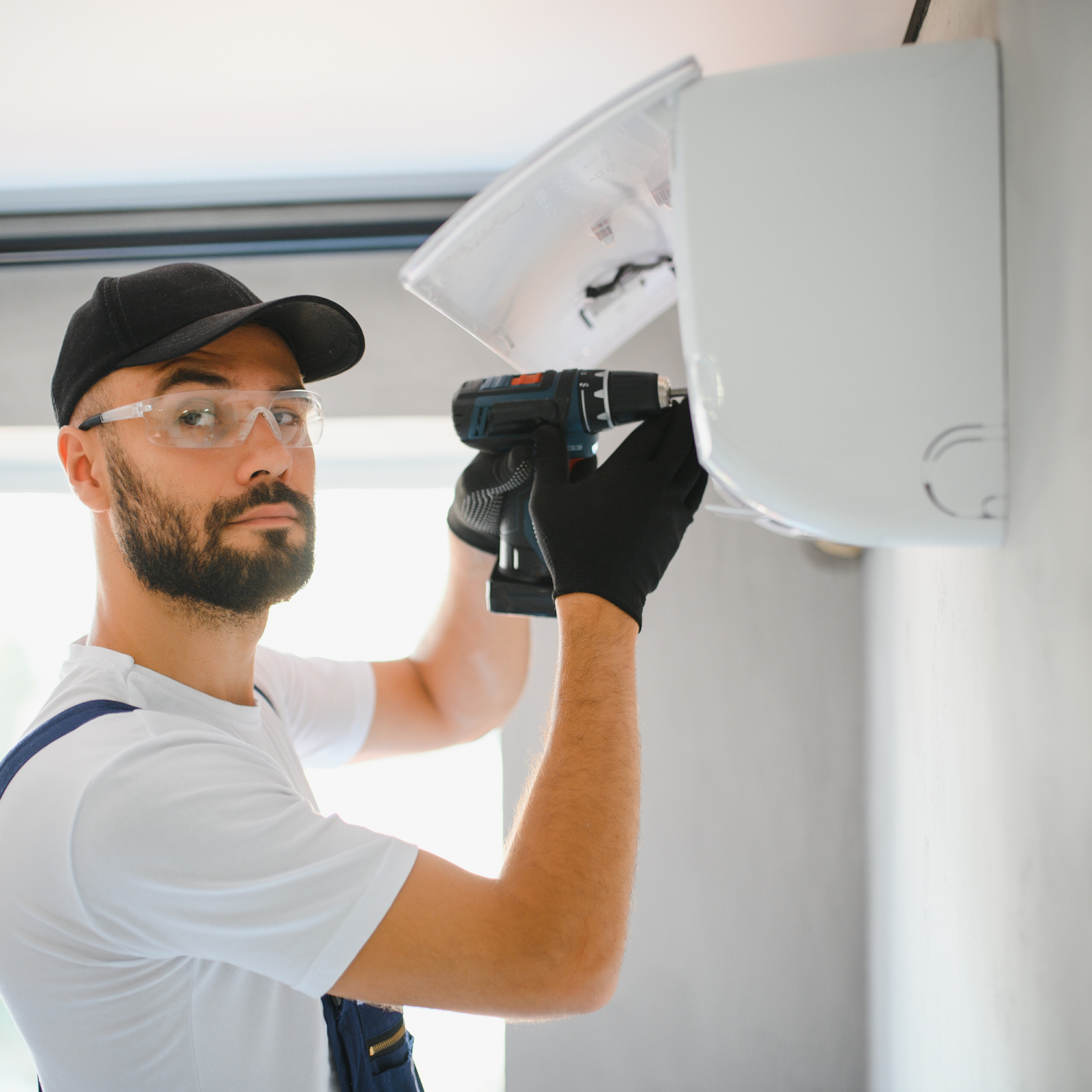 An aircon engineer repairing a home owners indoor ac unit